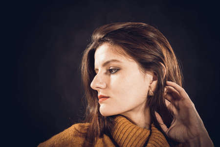 Studio portrait of young beautiful woman dressed in sweaterの写真素材