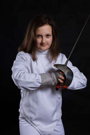 Teenage girl fencer dressed in uniform with epee and helmetの写真素材