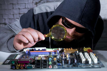 Bearded hacker in sunglasses and hoodie cracking the hardwareの写真素材
