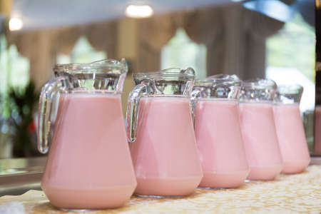 Rose yogurt in glass jars standing in a rowの写真素材
