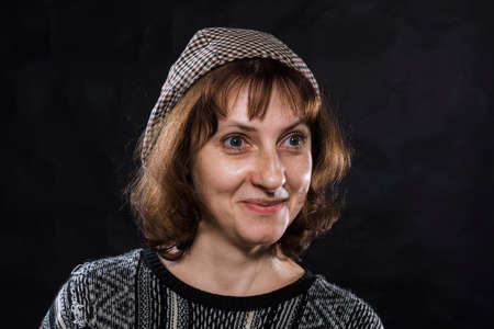 Cheerful 40 years old woman dressed in jeans and poncho studio portraitの写真素材