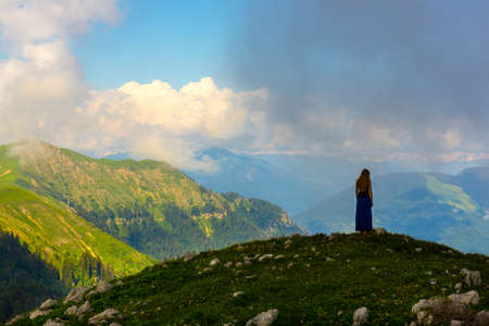 Beautiful mountain landscape at Caucasus mountains with woman standing far on the ridgの写真素材