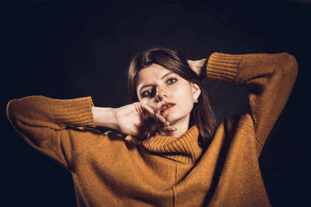 Studio portrait of young beautiful woman dressed in sweaterの写真素材
