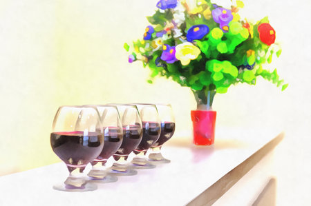 Wine glasses standig in a row with flowers in vaseの写真素材
