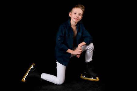 Young figure skater dressed in white jeans and blue shirtの写真素材