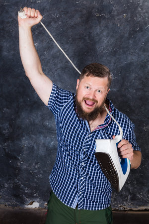 Solid bearded man at casual clothes having fun with iron