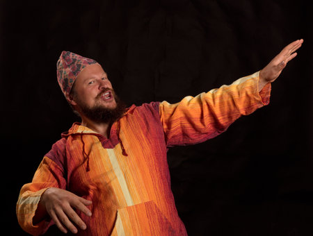 Joyful bearded man in bright orange shirt dancingの写真素材