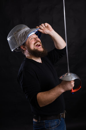 Middle aged bearded man with epee and helmetの写真素材