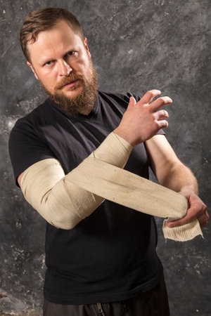 Matured man with bandaged hand studio portrait.の写真素材