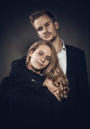 Young beautiful couple studio portrait on grey background.の写真素材
