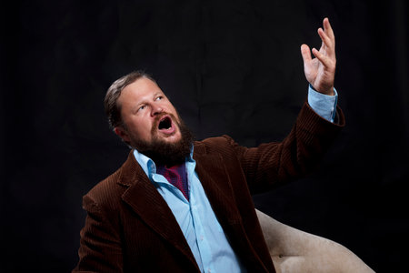 Stylish bearded man dressed in suit singing operaの写真素材