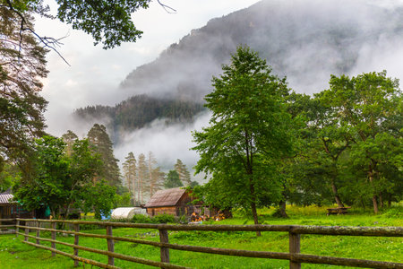 Beautiful scene with farm and cloudy mountainの写真素材