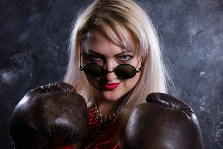 Attractive plump woman with boxing gloves studio portrait.の写真素材