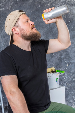 Joyful bearded foreman has a break with bottle of beerの写真素材