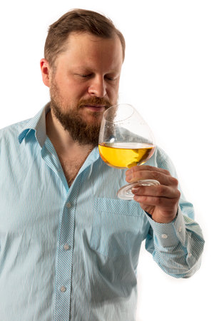 Solid bearded man in shirt tasting whisky studio portraitの写真素材