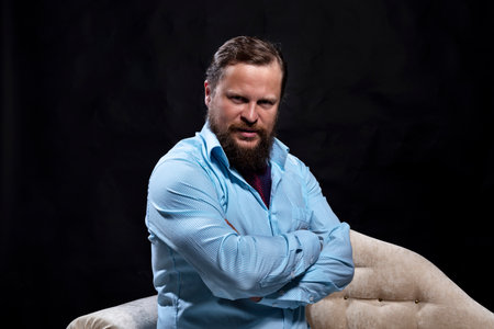 Confident solid bearded man dressed in shirt studio portraitの写真素材