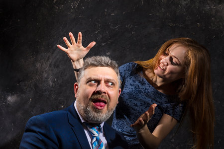 Bearded man and young woman, happy couple studio portrait..の写真素材