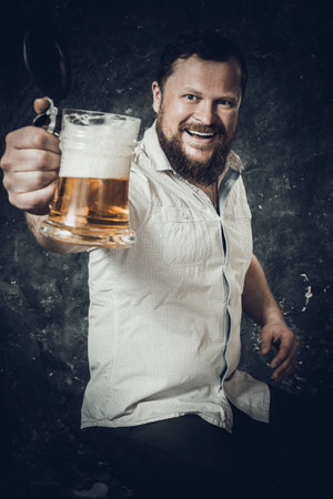 Matured smiling bearded man in shirt with beer mugの写真素材