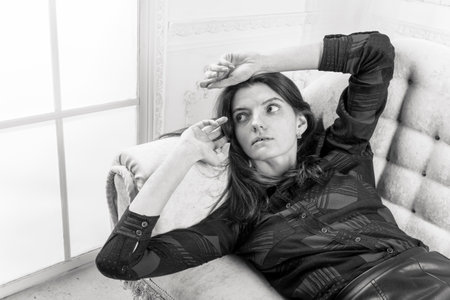 Portrait of young beautiful woman laying on sofaの写真素材