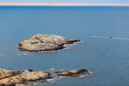 Beautiful seascape of small island in Barents sea with motorboatsの写真素材