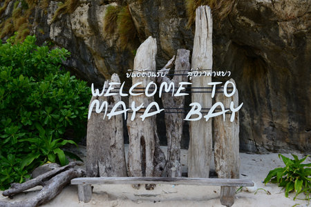 Thai and English letters on the log read Welcome to Maya Bay, for tourists to take a commemorative photoの写真素材