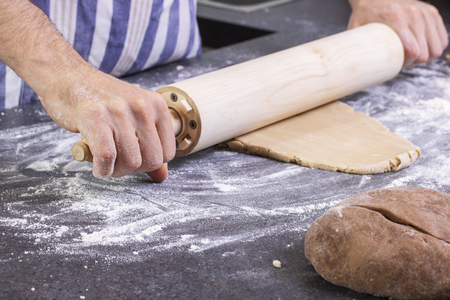Cook rolls out the dough on a board, the traditional cookingの写真素材