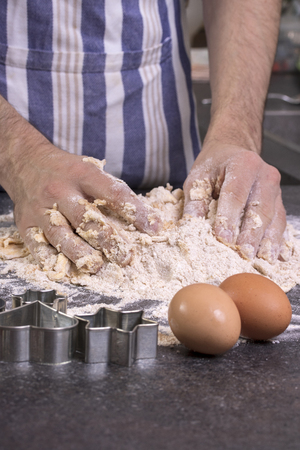 men's hands knead the doughの写真素材