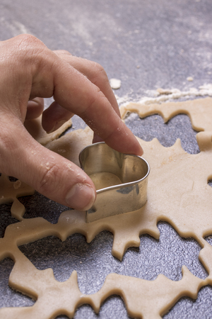 Heart shape is gouged in the dough by handの写真素材
