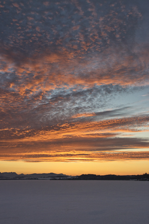Romantic sunset over a frozen lakeの写真素材