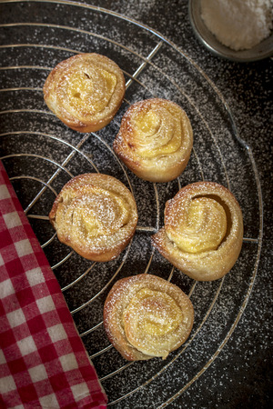 Small Vanilla snails with puff pastry on a cake rack, dark backgroundの写真素材