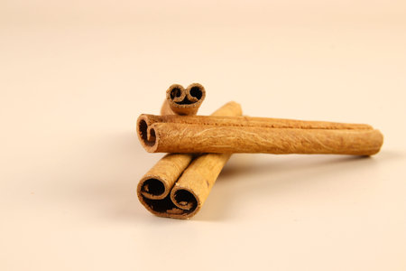 Cinnamon sticks on beige background with copy space.