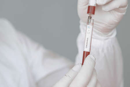 virus theme. Man in a protective suit. Doctor use a syringe.の写真素材