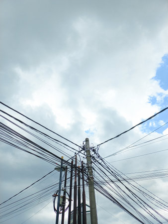 April, 15 2023, a cable and electricity pole that crosses the four lines of the house looks chaoticの写真素材
