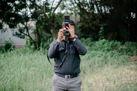 someone who is taking a photo of something towards the camera that took the photo in a yardの写真素材