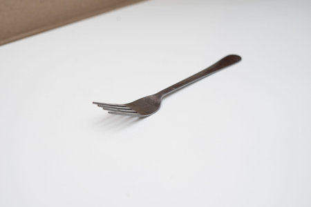 a fork placed on a white base