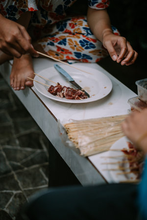 Slices of meat are prepared on skewers and then grilled on a meat grill.の写真素材