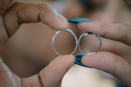 Newlyweds holding their wedding rings together, symbolizing their union and the beginning of a...
