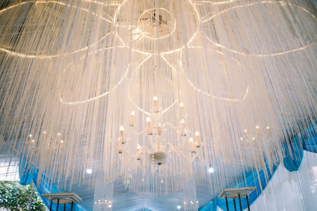 Opulent wedding decor featuring grand lighting fixtures, creating a luxurious and enchanting atmosphere for the celebrationの写真素材