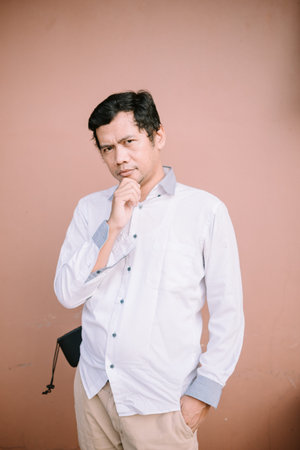 A man holding his chin with a puzzled expression, conveying curiosity or surprise