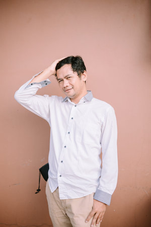 A man holding the right side of his hair, displaying frustration or deep thought.