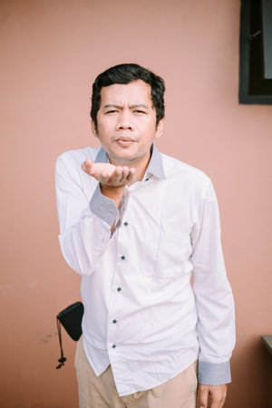 A man blowing something gently, capturing a moment of focused intentの写真素材