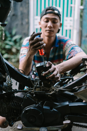 A motorcycle mechanic inspecting a damaged engineの写真素材
