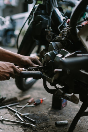 A motorcycle mechanic inspecting a damaged engineの写真素材