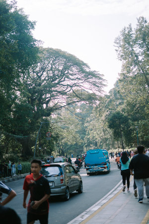Bogor, mei 26 2024. People passing by, engaging in various recreational activities, heading towards a spacious sports facility, a hub for public fitness and leisureのeditorial素材