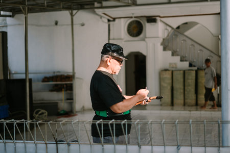 Bogor, Juni 17 2024. A man checks notes on sacrificial goats in a mosque yard celebrating Eid...