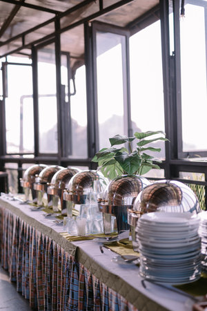 Empty food containers with plates and spoons, prepared in anticipation of freshly cooked meals