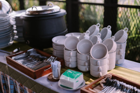 Iron pot for serving soup, paired with bowls and spoons, ready for a hearty meal.の写真素材