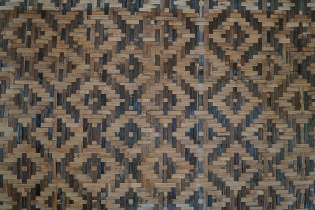 Wall made of woven bamboo in a square pattern, showcasing traditional craftsmanship and natural...