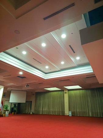 View from beneath a large indoor space with ceiling lights integrated into the roof, showcasing...