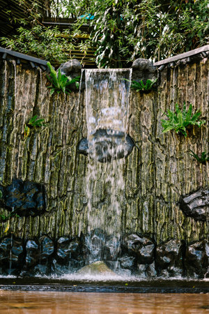 A man-made waterfall cascades gracefully, blending natural beauty with architectural designの写真素材